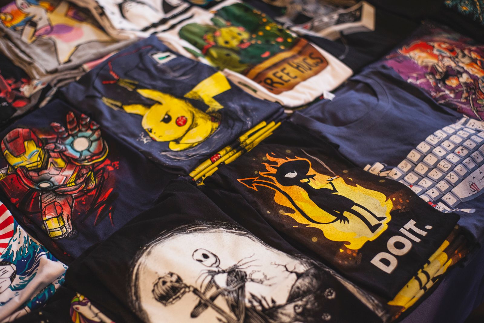 Un assortiment vibrant de t-shirts graphiques mettant en avant des personnages populaires dans un cadre de marché.